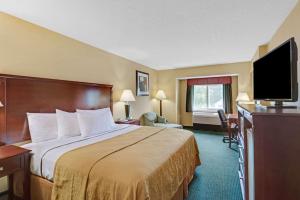 a hotel room with a bed and a flat screen tv at Ramada by Wyndham Kittery in Kittery