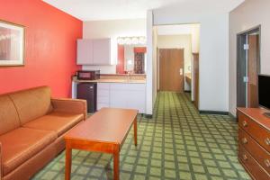 a living room with a couch and a kitchen at Baymont by Wyndham Decatur IL North in Forsyth