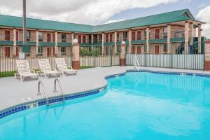 einen Pool in einem Resort mit Stühlen und einem Gebäude in der Unterkunft Ramada Limited San Angelo in San Angelo