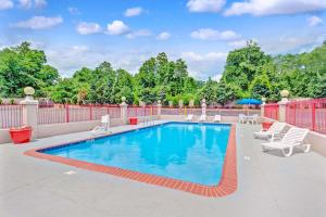 una piscina con sillas y una valla en Ramada by Wyndham Baltimore West, en Catonsville
