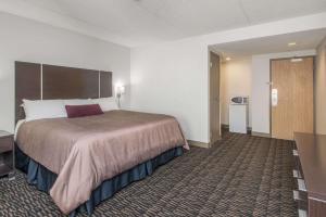 a hotel room with a large bed and a bathroom at Ramada Plaza by Wyndham Niagara Falls in Niagara Falls