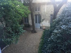 a garden with trees and a house with a door at Duplex Face au Palais in Avignon