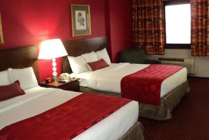 two beds in a hotel room with red walls at Ramada by Wyndham Yonkers - Westchester in Yonkers