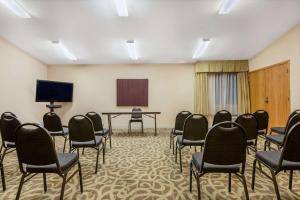 a room with chairs and a table and a screen at Ramada by Wyndham Columbus North in Westerville