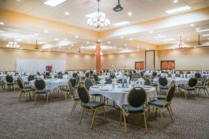 un salón de banquetes con mesas y sillas en una habitación en Ramada by Wyndham Des Moines Tropics Resort & Conference Ctr en Urbandale