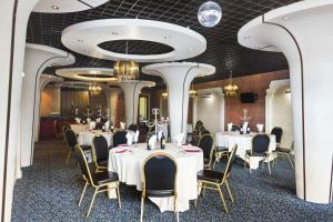 a dining room with tables and chairs and ceilings at Redwings Lodge Birmingham in Oldbury +16 photos