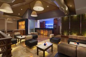 a restaurant with couches and tables and a wine cellar at Ramada Resort by Wyndham Kochi in Cochin