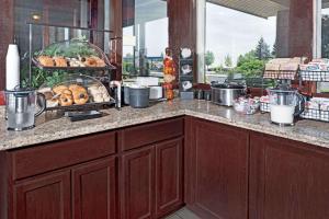 a kitchen with a counter with some pastries on it at Ramada by Wyndham Spokane Valley in Spokane Valley