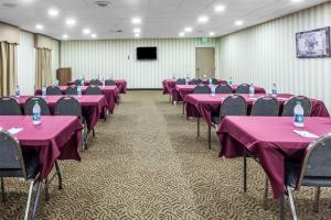 Una sala de conferencias con mesas y sillas rosas y una pantalla. en Ramada by Wyndham Lebanon, en Lebanon