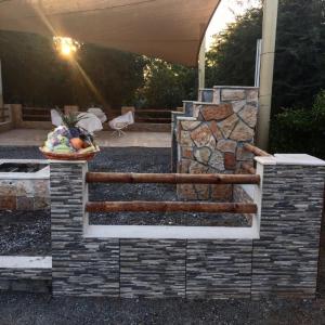 a stone fireplace in front of a house at Revaloo farm (Family Only) in Adhan