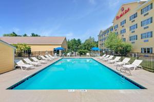 una piscina con sillas y un hotel en Ramada by Wyndham Saco/Old Orchard Beach Area, en Saco