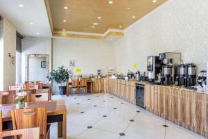 a restaurant with a counter and some tables and chairs at Ramada by Wyndham Flushing Queens in Queens