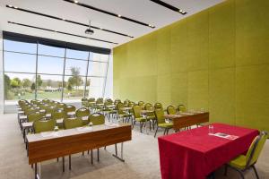 a conference room with tables and chairs with a red table cloth at Ramada Plaza by Wyndham Istanbul Asia Airport in Gebze