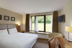 um quarto de hotel com uma cama e uma grande janela em Ramada Telford Ironbridge em Telford
