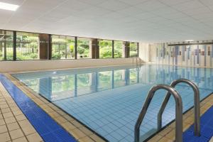 uma grande piscina com azulejos azuis num edifício em Ramada Telford Ironbridge em Telford