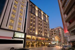 a tall building on a city street at night at Ramada Hotel & Suites by Wyndham Adana in Adana