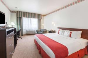 a hotel room with a bed and a dresser at Ramada by Wyndham Williams/Grand Canyon Area in Williams