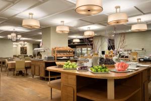 a cafeteria with a large table with fruit on it at Ramada Hotel & Suites by Wyndham Adana in Adana