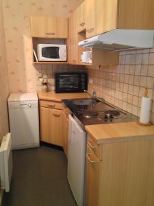 a small kitchen with a stove and a microwave at Appartement tout confort in Argelès-Gazost