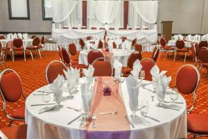 a banquet hall with white tables and chairs at Ramada by Wyndham Timmins in Timmins