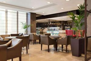 a restaurant with chairs and tables and a bar at Ramada Downtown Abu Dhabi in Abu Dhabi