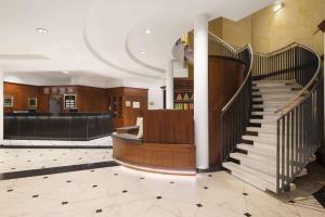 a lobby with a spiral staircase and a bar at Hotel Ramada Graz in Premstätten