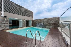 a swimming pool on the balcony of a building at Ramada Encore by Wyndham Lima San Isidro in Lima