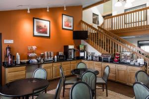 a waiting room with tables and chairs and stairs at Ramada by Wyndham Platte City KCI Airport in Platte City