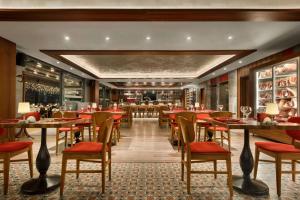 a restaurant with tables and chairs and a bar at Ramada Encore Eskişehir in Eskisehir
