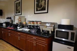 a kitchen with a counter top with a microwave at Ramada by Wyndham Sacramento in Sacramento