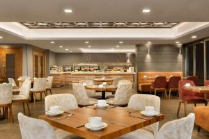 伯薩的住宿－Ramada By Wyndham Bursa Cekirge Thermal & Spa，一间带桌椅的餐厅和一间厨房