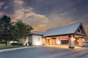 a building with a black roof on a street at Ramada by Wyndham Provo in Provo