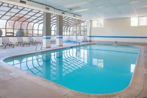 - une grande piscine d'eau bleue dans un bâtiment dans l'établissement Ramada by Wyndham Downtown Spokane, à Spokane