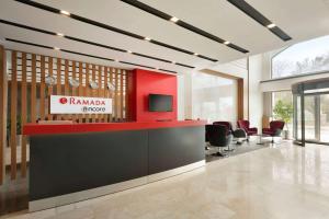 a lobby with a red and black counter and chairs at Ramada Encore Gebze in Gebze