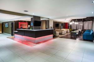 a hotel lobby with a bar and couches at Ramada by Wyndham Jacksons Point in Georgina