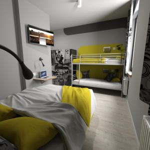 een slaapkamer met een bed met geel en wit bij La Guitarra Hostel Poznań in Poznań