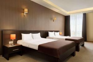 a hotel room with two beds and two lamps at Ramada by Wyndham Constanta in Constanţa +97 photos