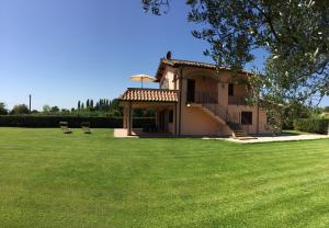 a house with two chairs in a large yard at Agriturismo Battaglini in Bolsena