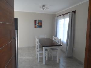 a dining room with a table and chairs and a window at La soleada in San Clemente del Tuyú