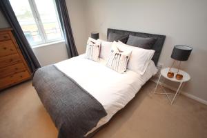 a bedroom with a large bed with white sheets and pillows at Napoleon Apartment in Leamington Spa