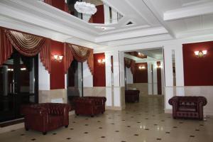 eine Lobby mit roten Wänden und Stühlen und einer Decke in der Unterkunft Bogemia Hotel on Vavilov Street in Saratow