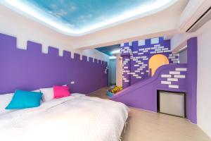 1 dormitorio con cama y pared púrpura en 墾丁南灣海遇親子 Meet you Nanwan, en Nanwan