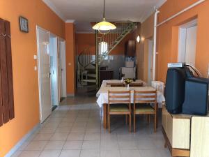 a dining room with a table and chairs and a television at Napsugár Vendégház in Kehidakustány