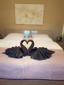 Dos toallas en forma de corazón en una cama en Ferienhaus Richter en Bad Schandau