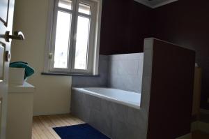 a bathroom with a bath tub and a window at Vakantiehuis Jeanne Panne in Nieuwpoort