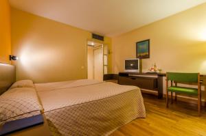 1 dormitorio con 1 cama y escritorio con ordenador en Hotel Sant Eloi, en Sant Julià de Lòria