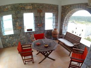 a table and chairs in a room with a stone wall at Mezapos Villa Katerina in Mézapos +38 photos