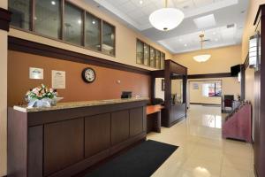 an office lobby with a reception counter and a clock at Days Inn by Wyndham Brampton in Brampton