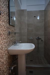 a bathroom with a sink and a shower at Lafazanis rooms in Nea Vrasna