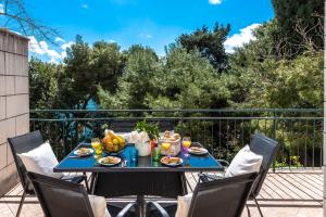 una mesa con comida y fruta en el balcón en Dream Estate, en Dubrovnik